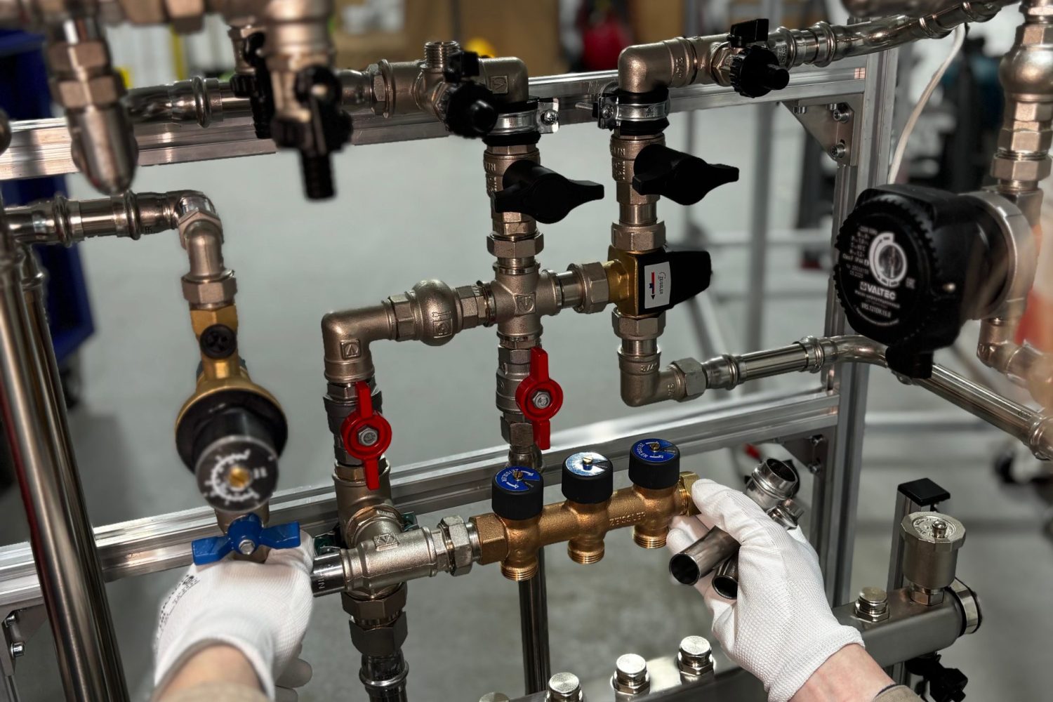Engineer adjusting metal pipeline valves in an industrial setting with precision.